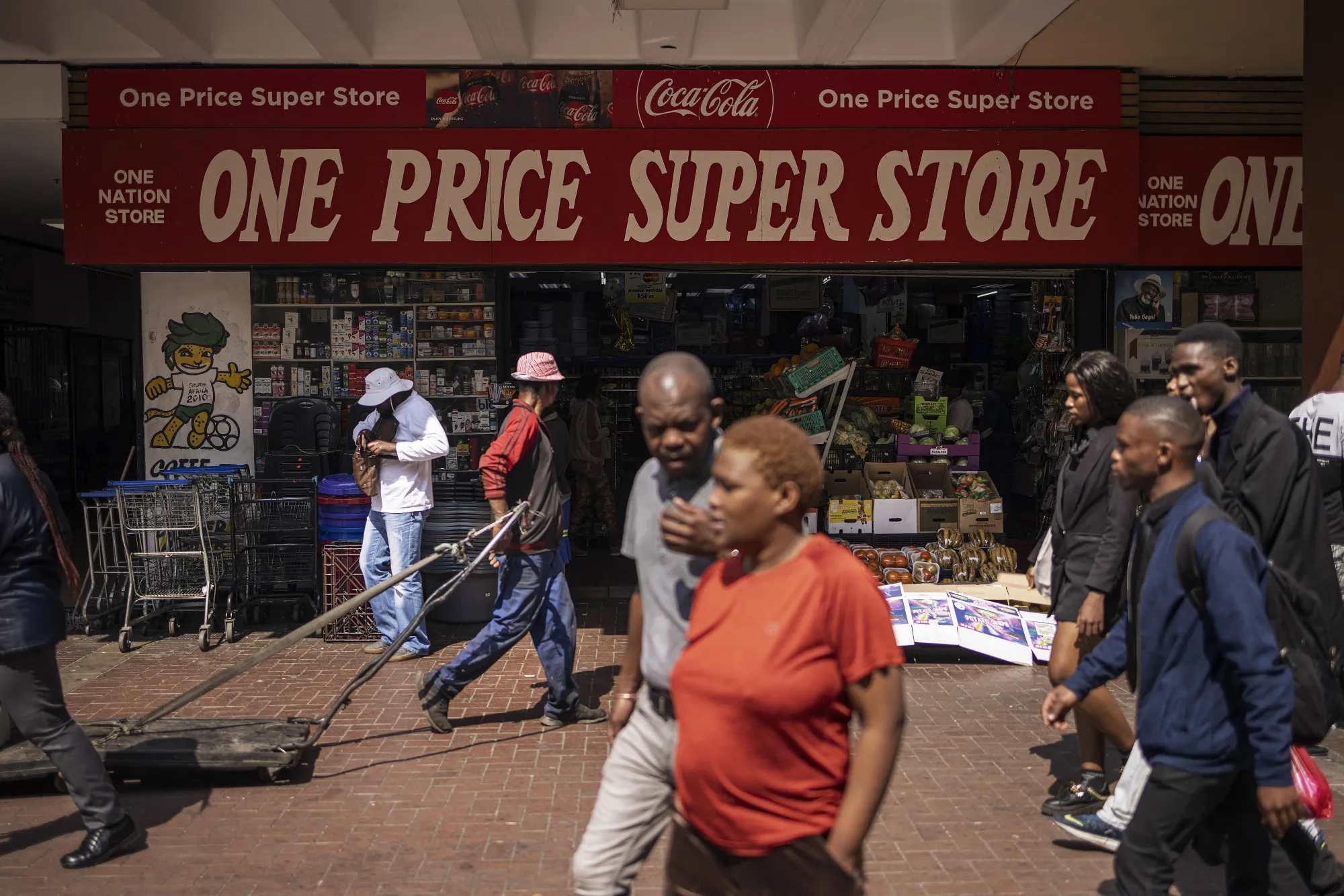 Pedestrians pass a grocery store in the Randburg Central Business District of Johannesburg, South Africa.