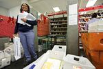 United States Postal Service (USPS) letter carrier Lakesha Dortch-Hardy smiles as she sorts mail at the Lincoln Park carriers annex in Chicago.