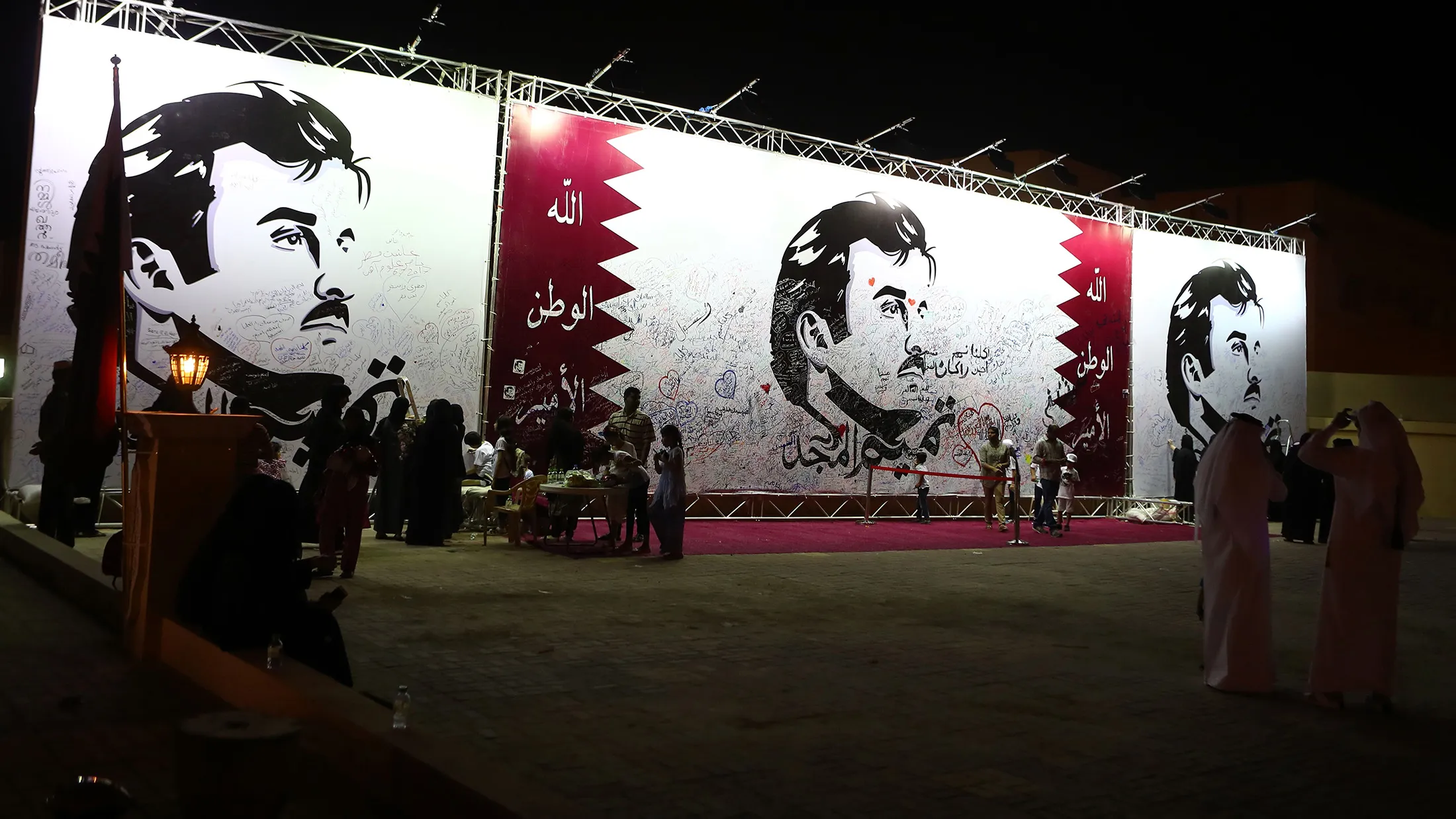 Qataris write comments on a wall bearing a portrait of Qatar's Emir, Sheikh Tamim bin Hamad Al Thani, which has become the symbol of Qatari resistance during the month-long row between Doha and neighbouring countries, in Doha, on July 6, 2017. / AFP PHOTO / KARIM JAAFAR (Photo credit should read KARIM JAAFAR/AFP/Getty Images)
