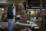 A factory worker uses a piece of machinery to cut wooden components at the Colonial House Furniture Inc. wood shop in Auburn, Kentucky, U.S., on Wednesday, Dec. 1, 2021.