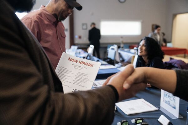 Attendees shake hands at an Employment and Resource Fair in Long Beach, California.