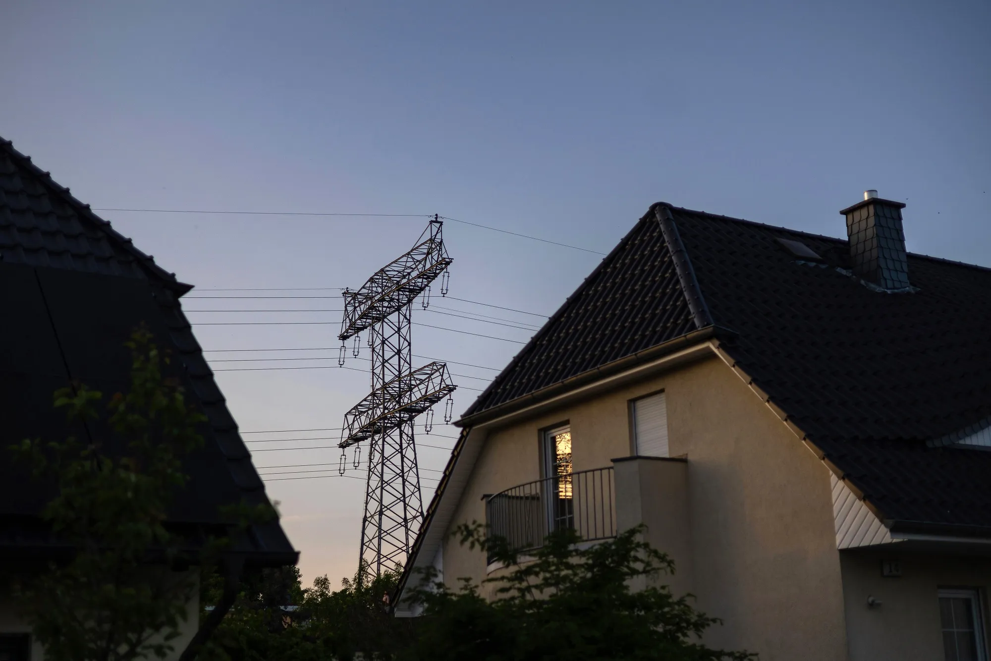 An electricity transmission pylon next to residential houses in Berlin.
