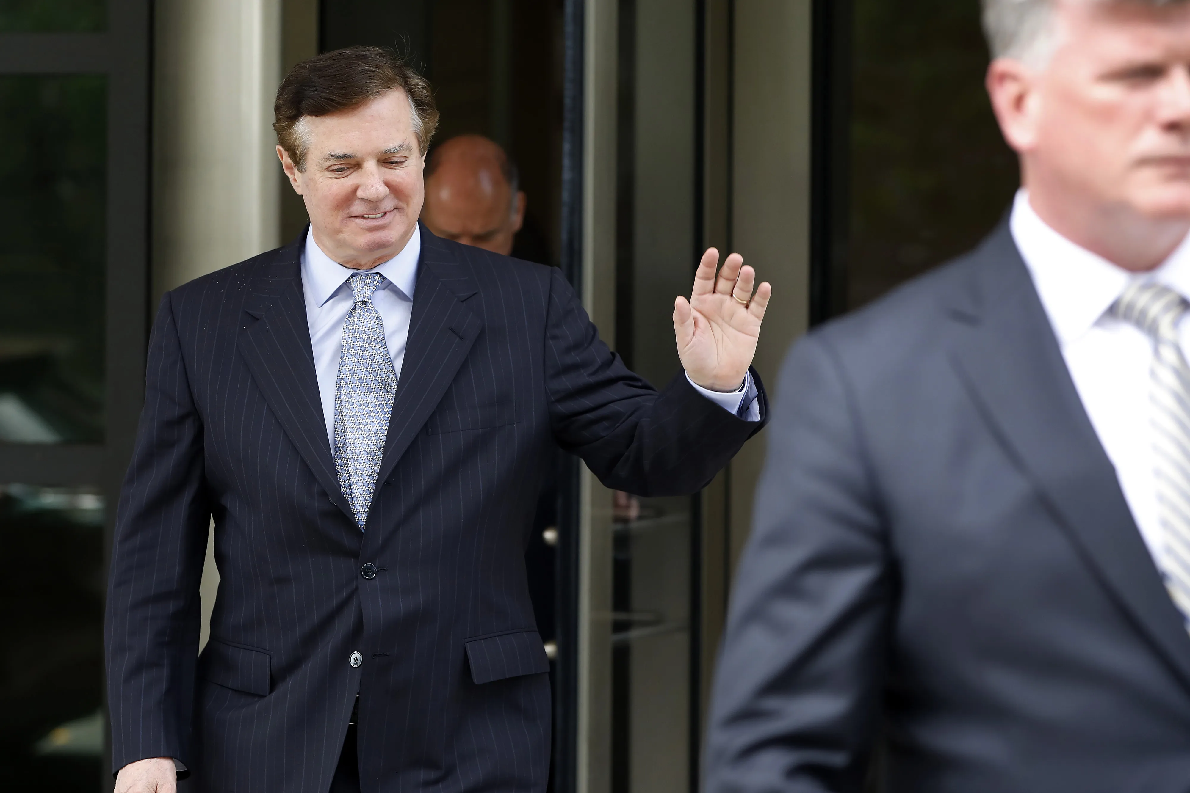 Paul Manafort waves while exiting federal court in Washington, D.C. on May 23, 2018.