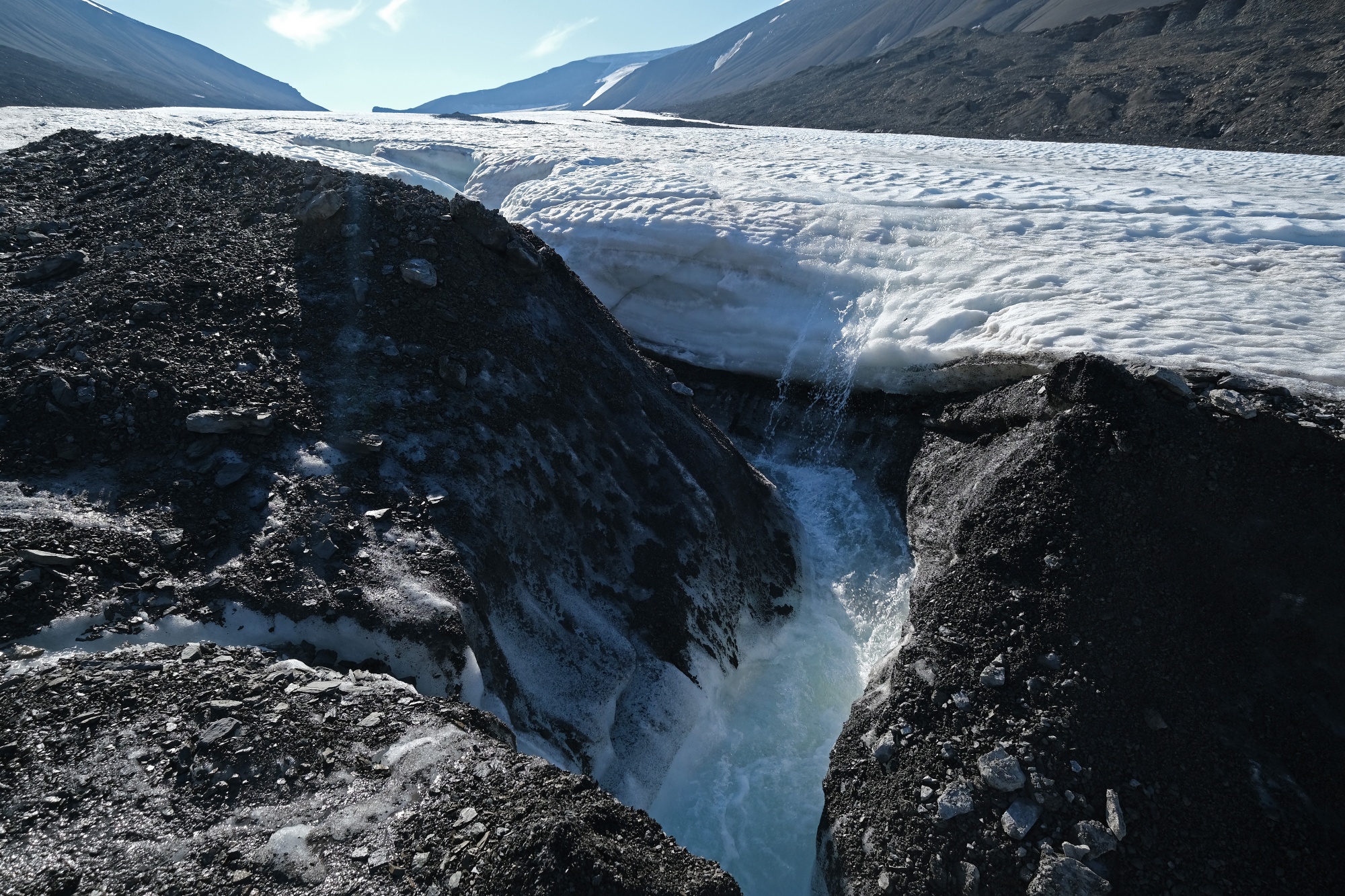Water flows down from a winding channel on the surface of the melting Longyearbreen glacier during a summer heat wave near Longyearbyen, Norway on July 31, 2020.