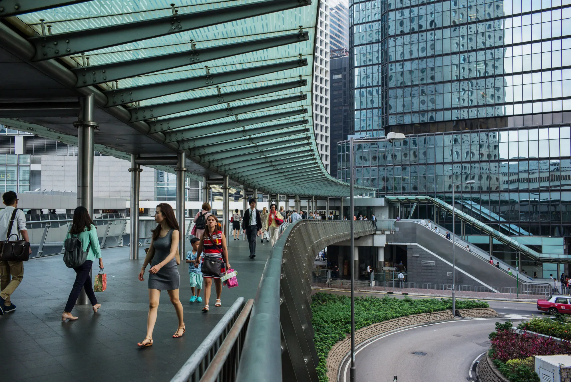 Pedestrians walk along a footbridge in the Central district of Hong Kong, China.