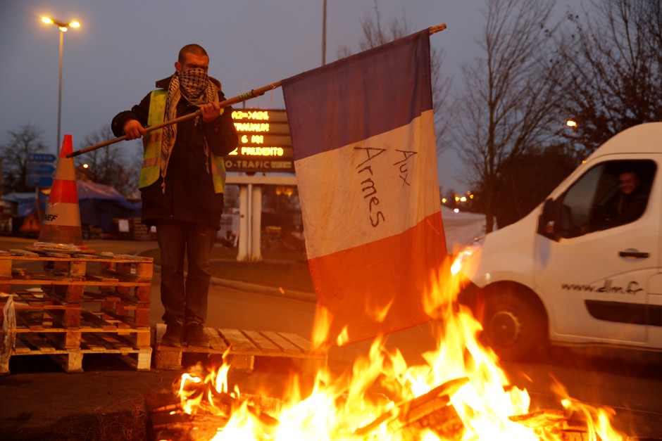 A protester wears a yellow vest, the symbol of a French drivers' protest against higher diesel fuel prices.
