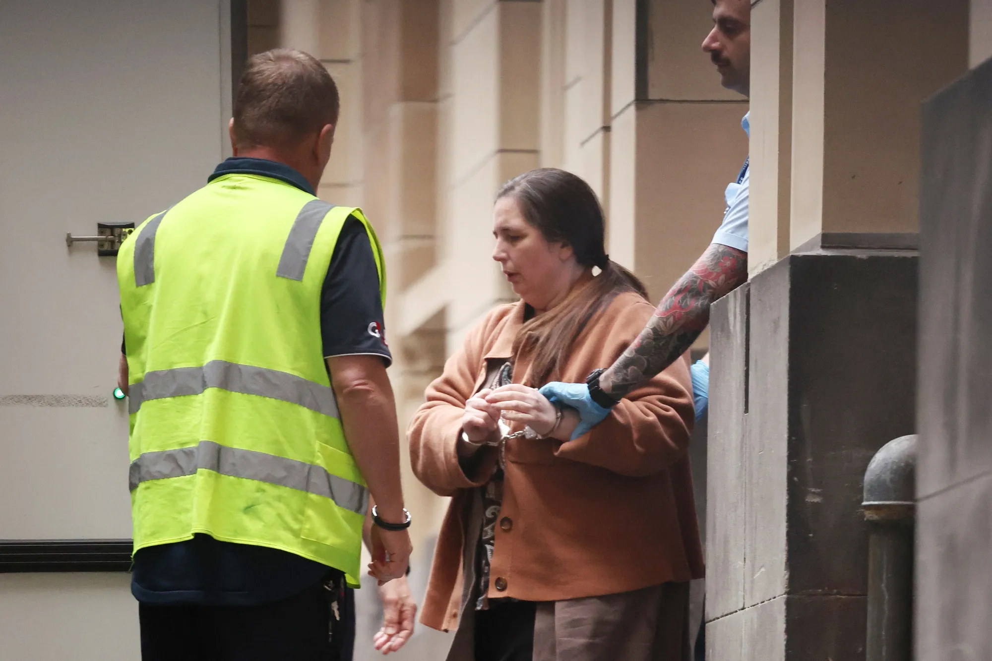 Erin Patterson is escorted out of the Supreme Court of Victoria in Melbourne on Aug. 25.