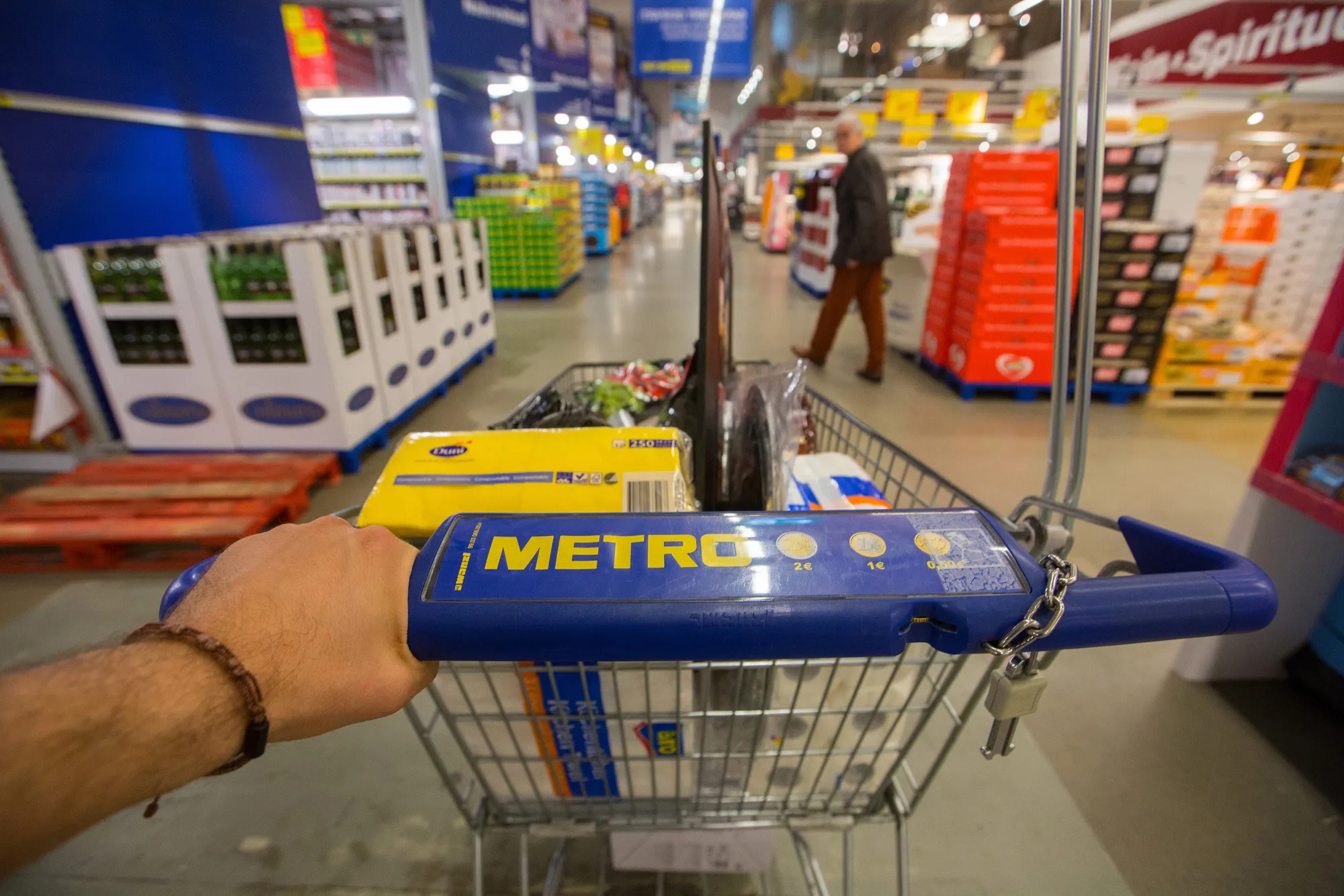 A customer pushes a shopping cart in this arranged photograph inside a Metro AG Cash &amp; Carry wholesale store in Duesseldorf, Germany, on , April 5, 2016.
