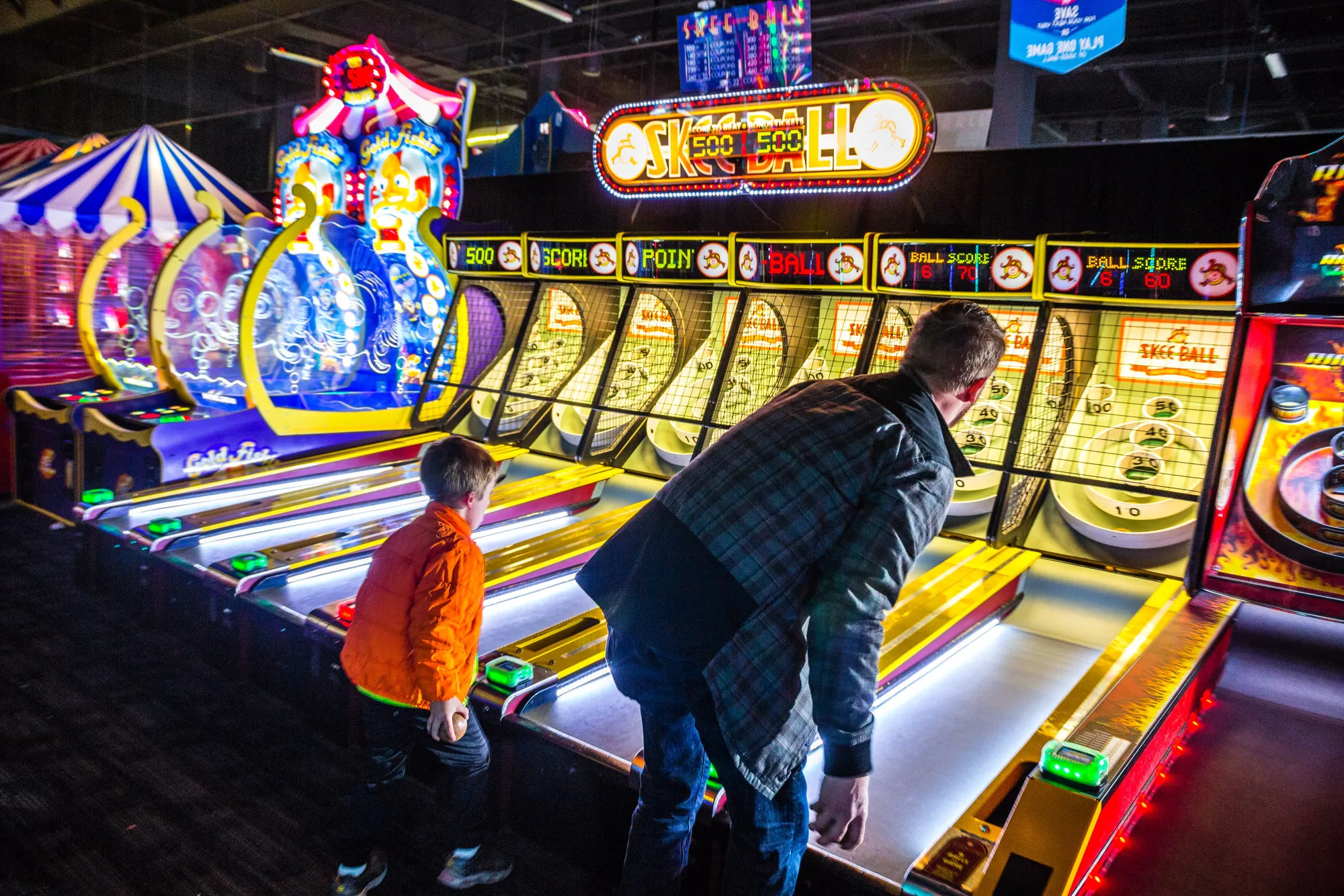Customers play skee ball at a Dave &amp; Buster's.