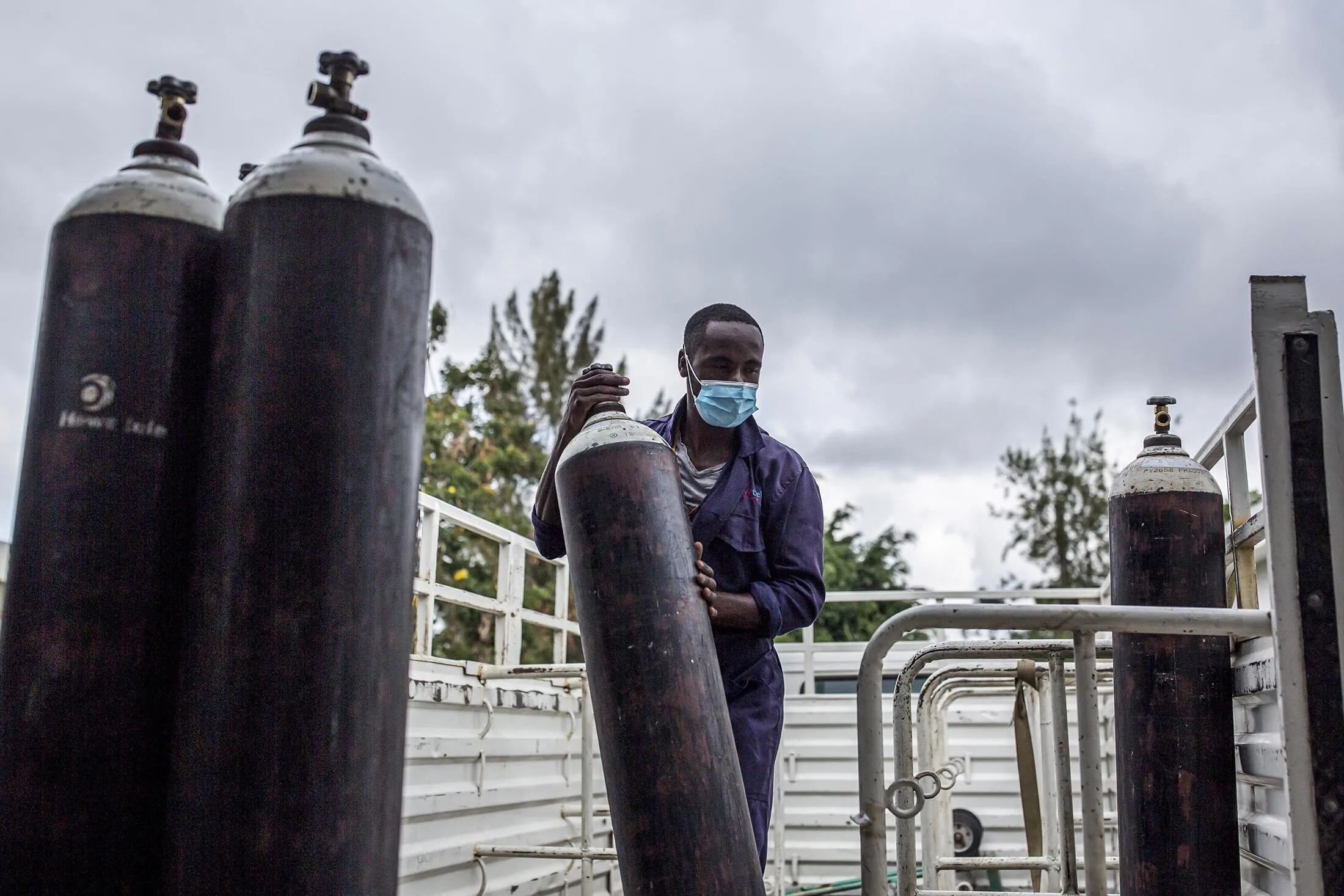 Unloading oxygen tanks after a delivery.