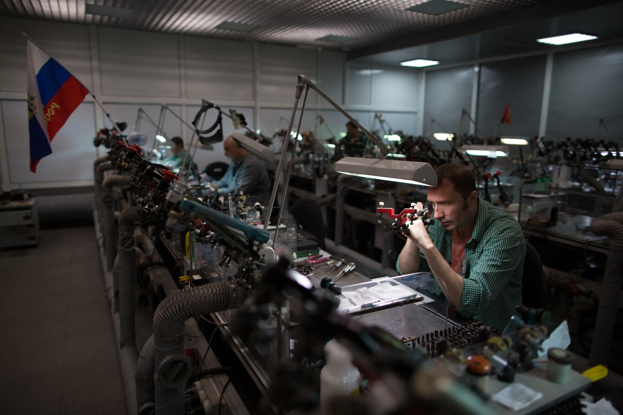 A worker uses a magnifying glass to inspect a cut diamond in Moscow, Russia.