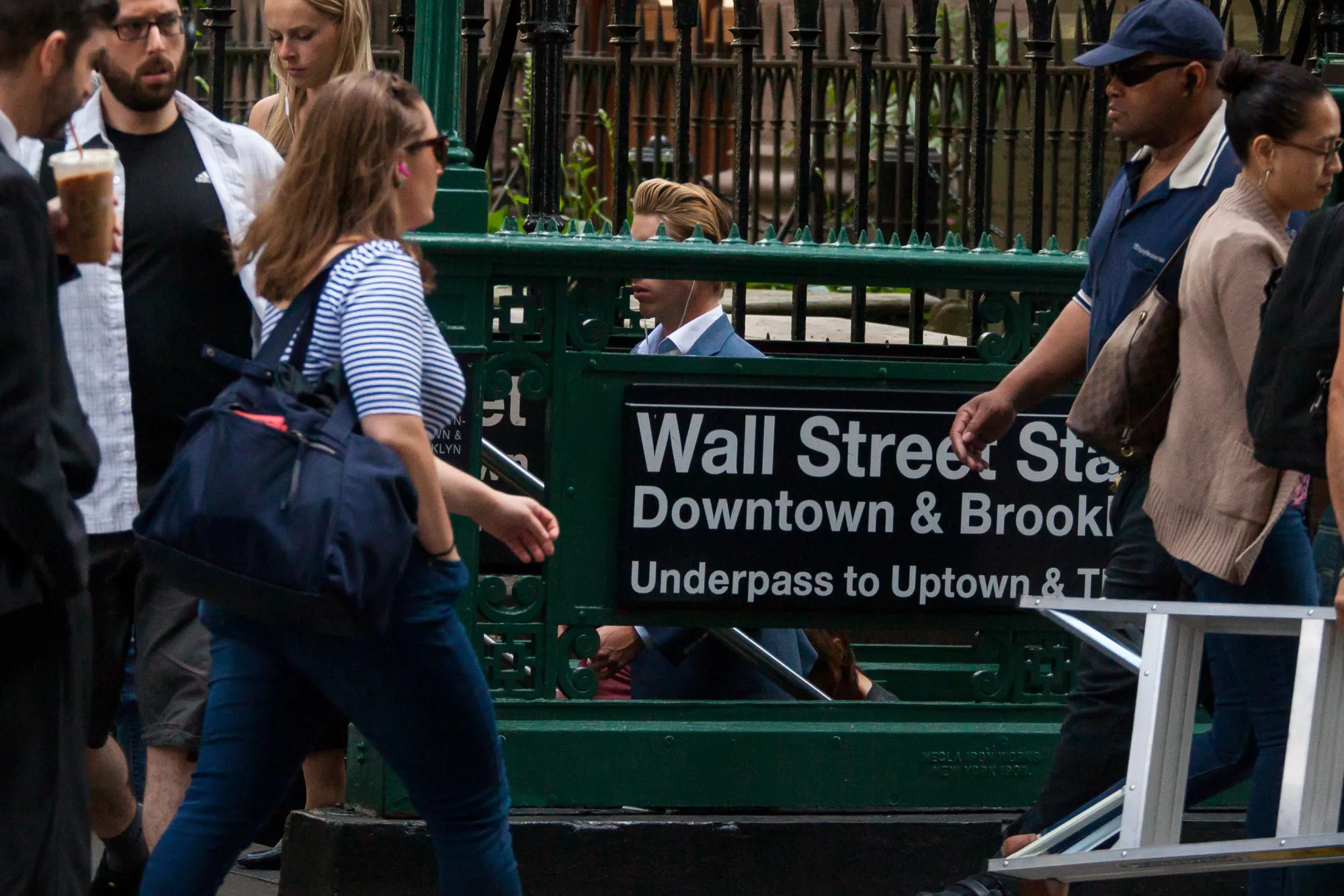 Pedestrians pass the Wall Street subway station near the New York Stock Exchange.