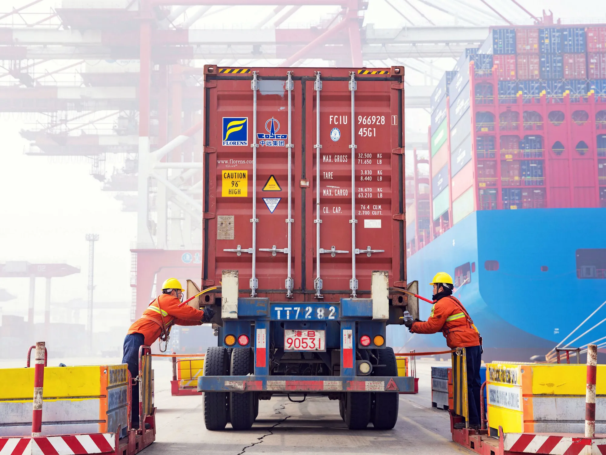 Workers prepare a container at the port in Qingdao, China's eastern Shandong province.