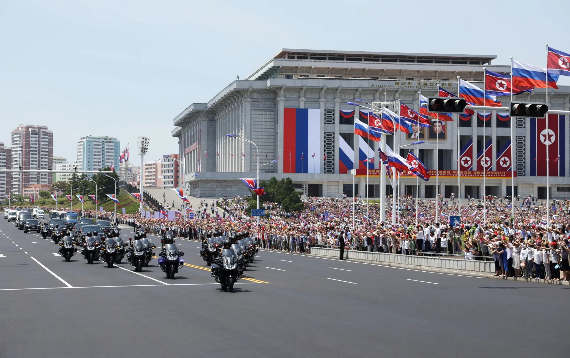 In a photograph distributed by Russian state media,&nbsp;people stand along a street to greet the convoy carrying&nbsp;Vladimir Putin in Pyongyang on June 19.&nbsp;