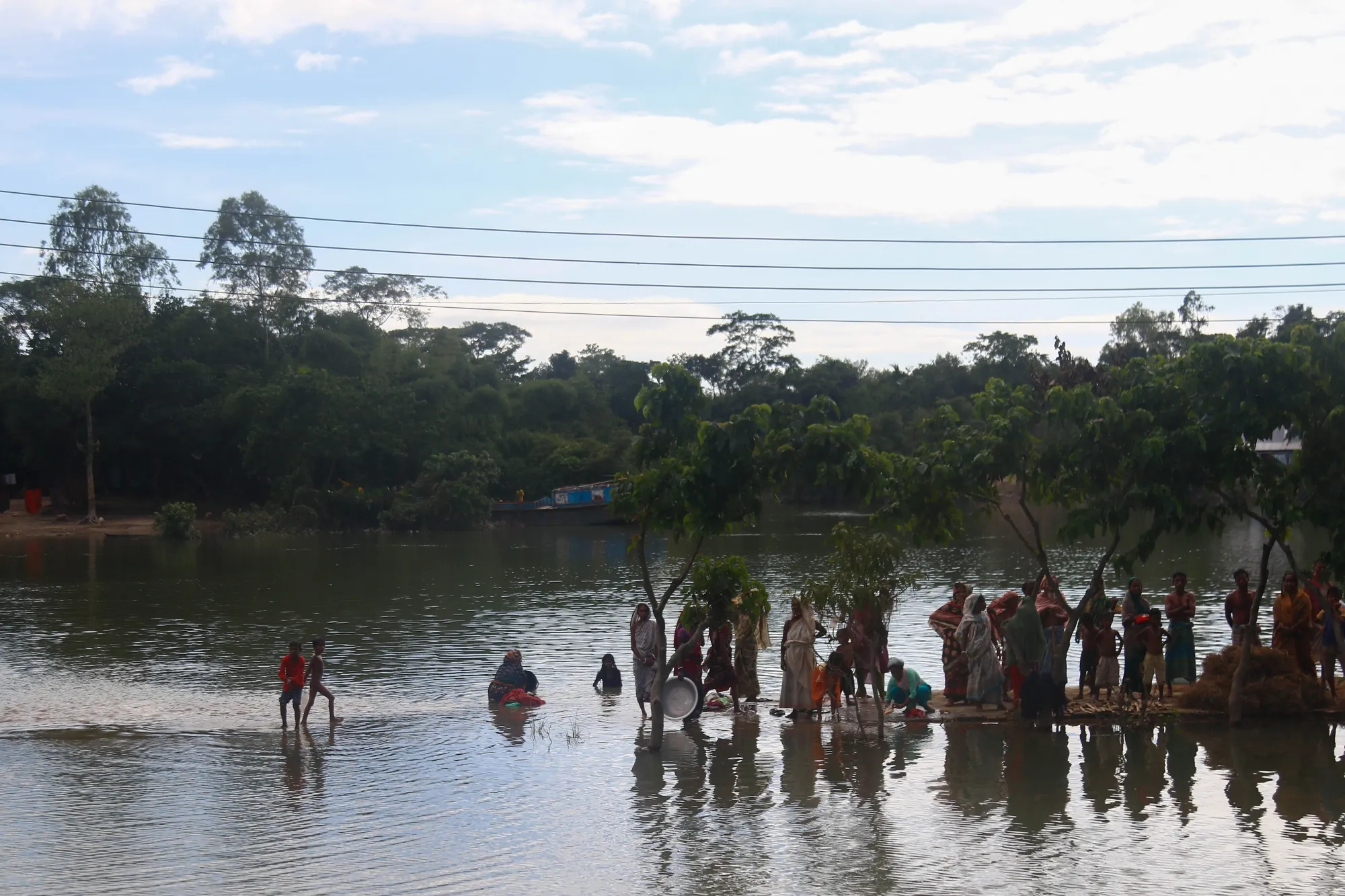 Disaster-affected residents wait in floodwater to receive relief items in Sylhet, Bangladesh, in June 2022.&nbsp;