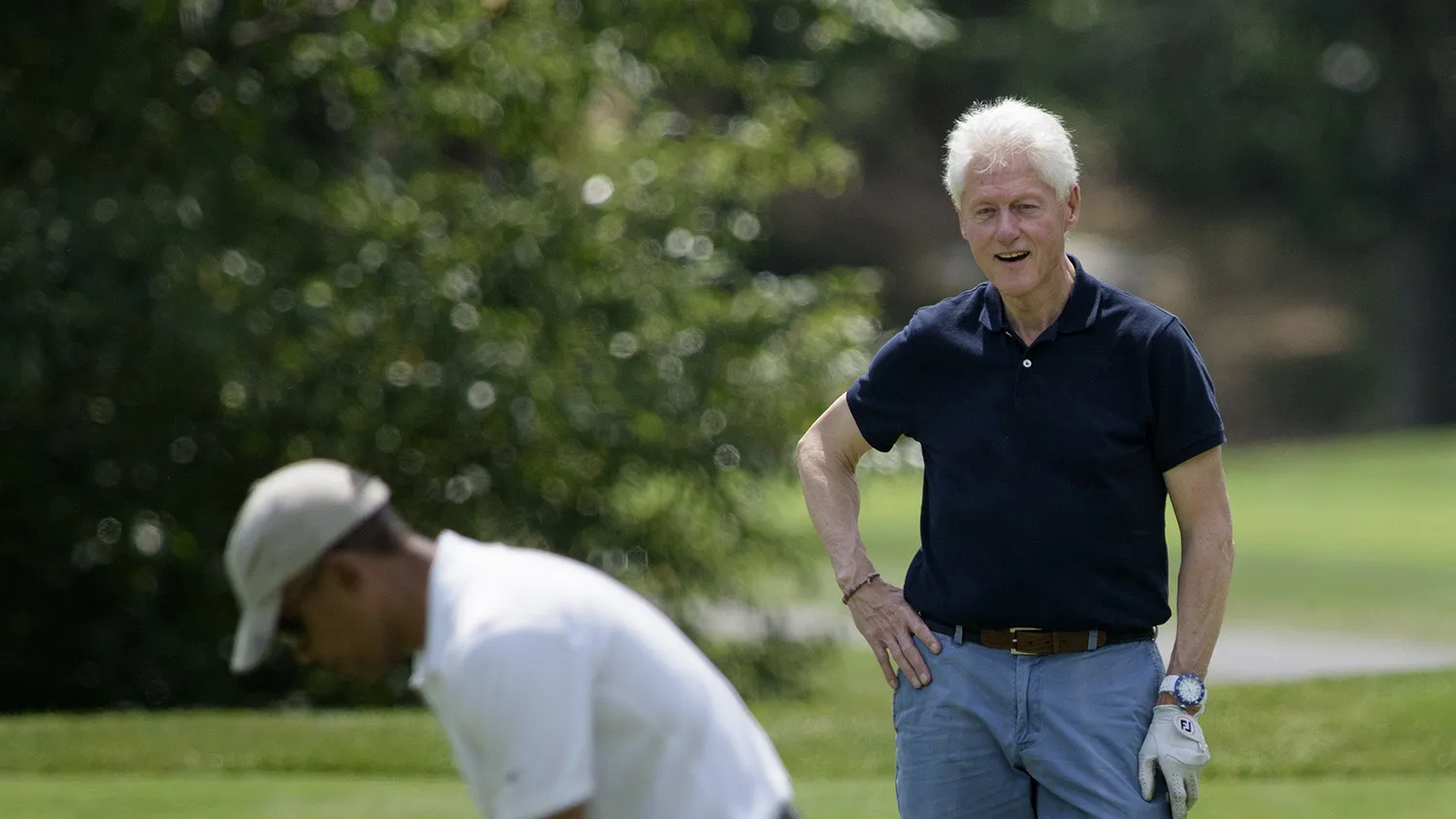 Former US President Bill Clinton (C) and Ron Kirk (R) watch as US President Barack Obama putts while golfing at Farm Neck Golf Club August 15, 2015 in Oak Bluffs, Massachusetts on Martha's Vineyard. AFP PHOTO/BRENDAN SMIALOWSKI (Photo credit should read BRENDAN SMIALOWSKI/AFP/Getty Images)
