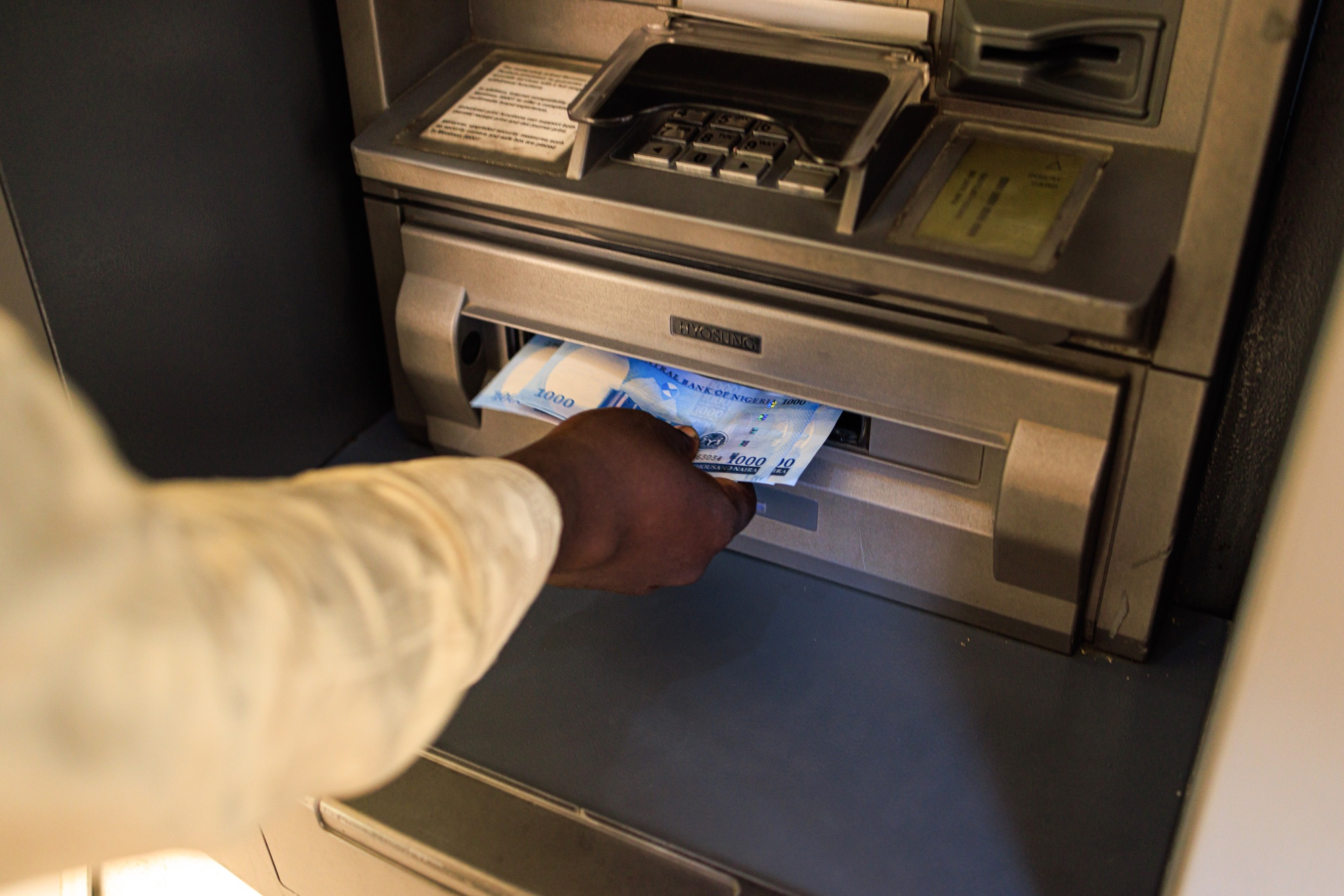 A customer withdraws newly-designed Nigerian 1,000-naira banknotes from an ATM in Lagos, Nigeria, on Monday, Feb. 6, 2023.