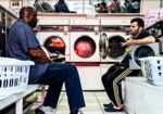 Two customers chat at a laundry in Cricklewood, Northwest London.