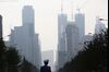 A police officer stands in front of buildings in Dalian, China, on Friday, Sept. 13, 2013. Goldman Sachs Group Inc. this month raised its estimate for China's economic growth for the third and fourth quarters, citing improving global demand and a stronger-than-expected domestic industrial recovery.