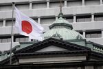 A Japanese national flag flies outside the Bank of Japan (BOJ) headquarters in Tokyo, Japan.