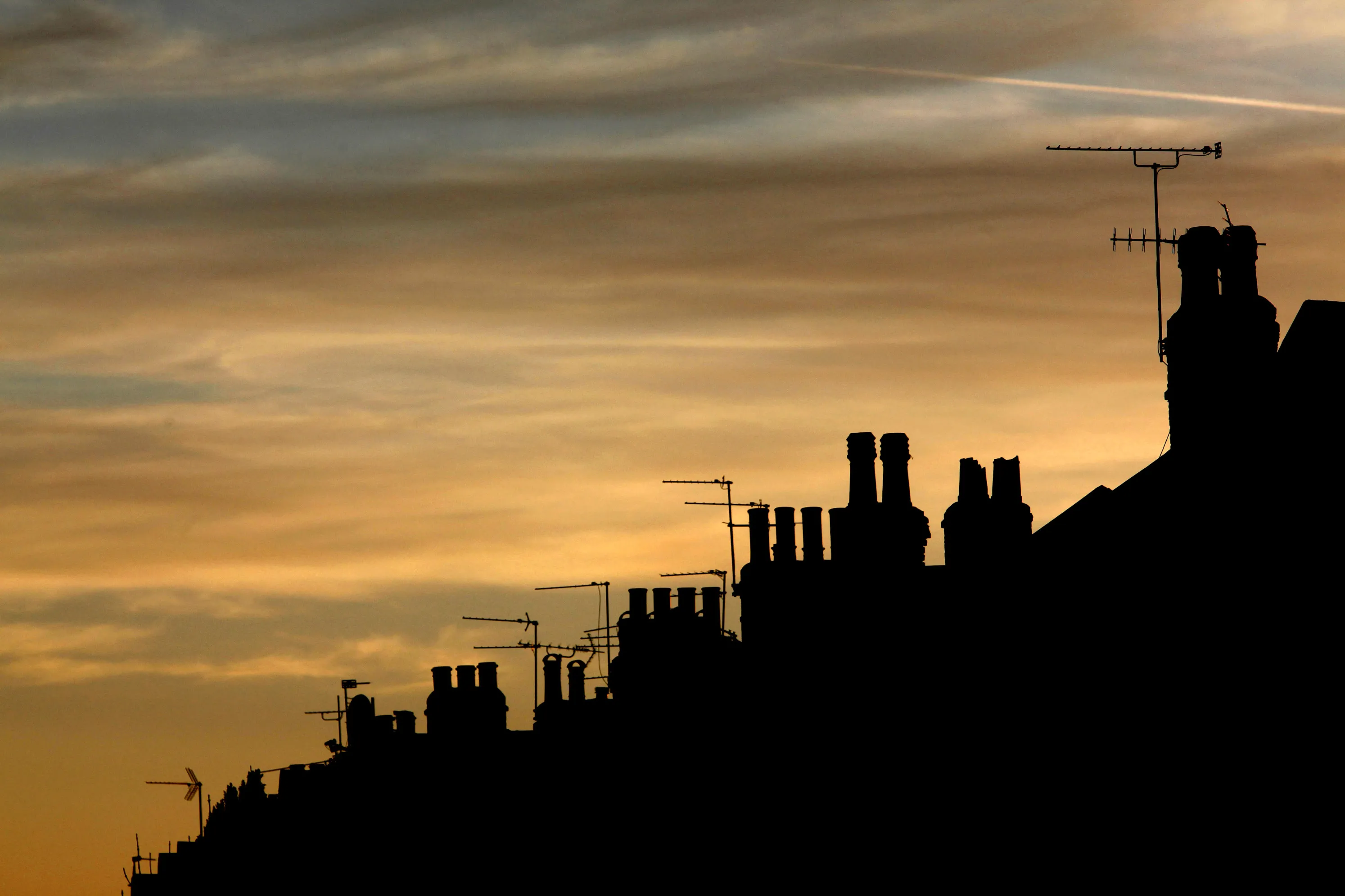 A row of terrace houses is silhouetted against a sunset in London, U.K., on Sunday, April 19, 2009. The pound 's 20 percent drop in the past year made Britain the first choice when Schroders Plc started buying real estate in Europe last month.