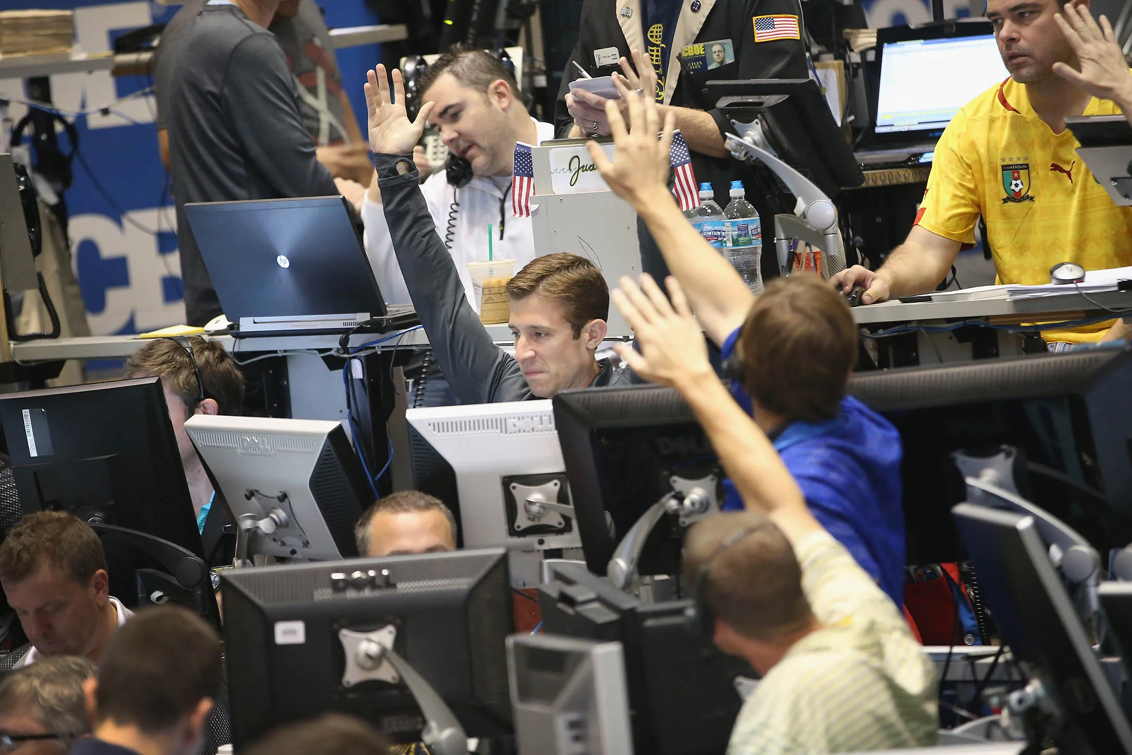 CHICAGO, IL - JULY 30: Trader signal offers in the CBOE Volatility Index (VIX) pit at the Chicago Board Options Exchange (CBOE) in front of the Federal Open Market Committee statement on July 30, 2013 in Chicago, Illinois. Investors are looking for guidance on the overall health of the economy and are anticipating the Fed will announce another reduction in its monthly bond purchases when it releases its policy statement this afternoon.
