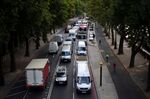 Cars sit in a traffic jam while cyclists ride by in Central London.