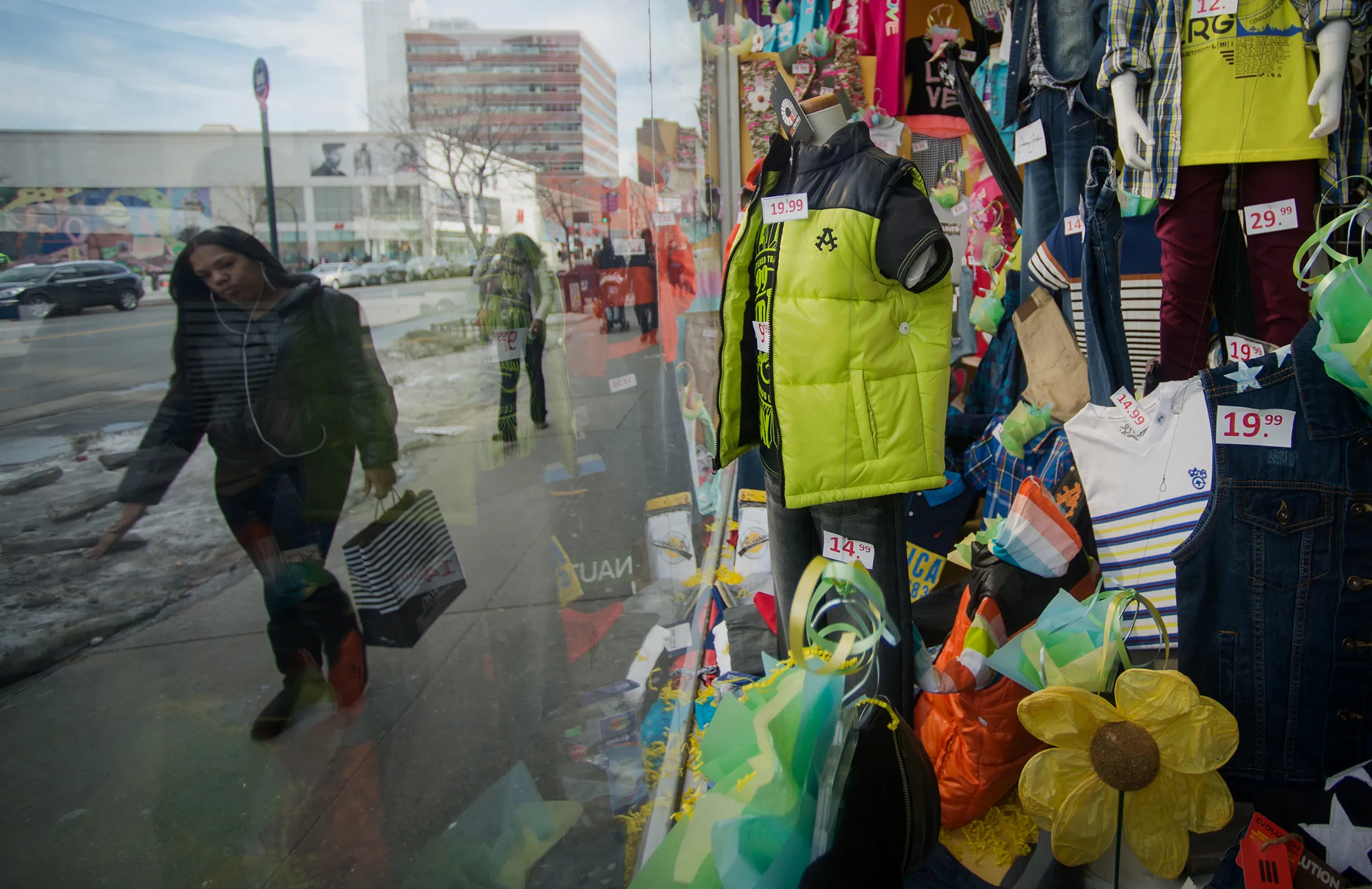Pedestrians walk past the display window of a store in the Harlem neighborhood of New York.
