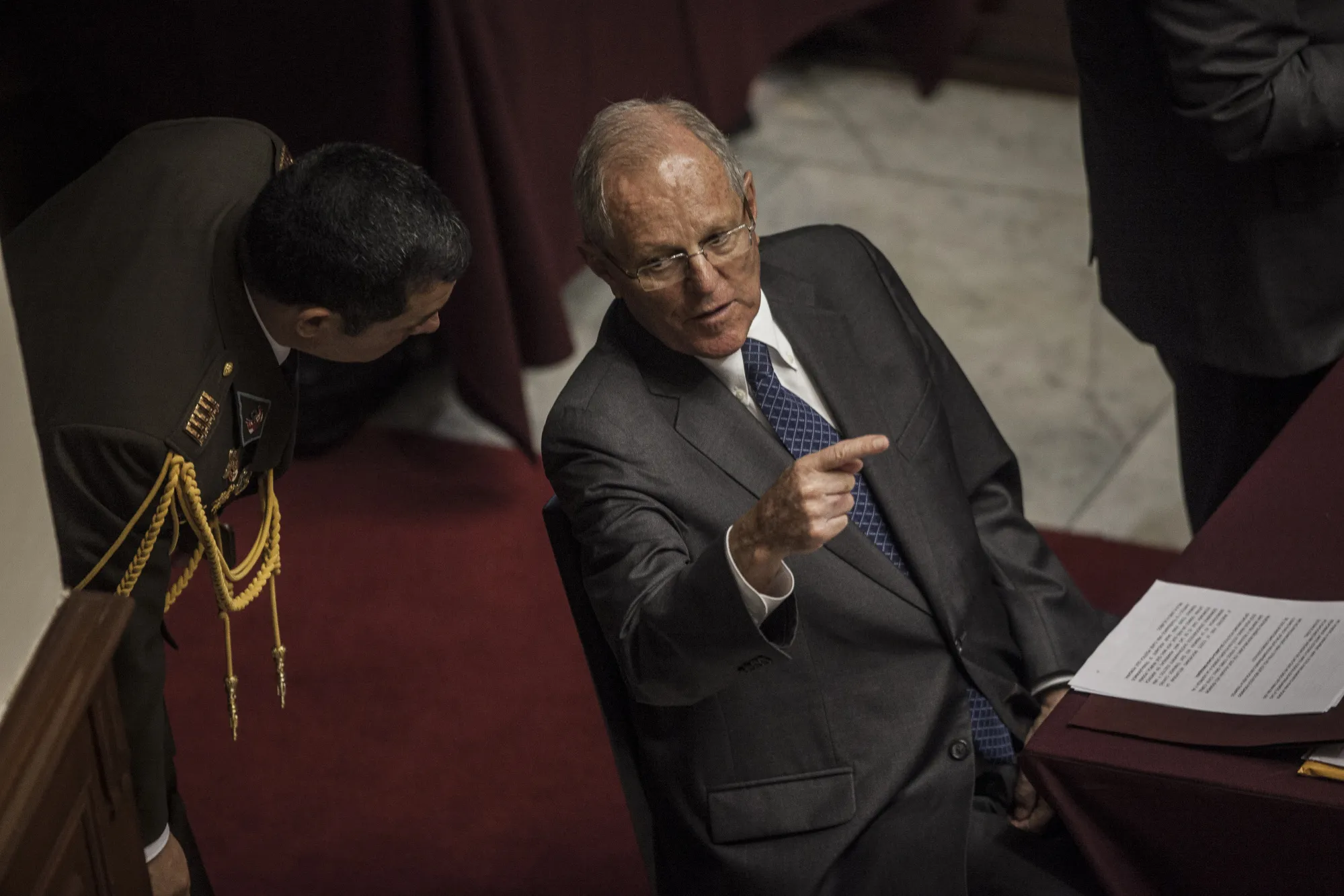 Pedro Pablo Kuczynski speaks with a guard during impeachment proceedings at the National Congress in Lima&nbsp;on&nbsp;Dec. 21, 2017.