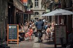Customers dine on the terraces of bars and restaurants lining a pedestrianized street in Bordeaux, France.