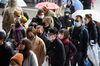 Tourists wearing face masks walk along a shopping street leading to the Sensoji temple in the Asakusa district of Tokyo, Japan, on Tuesday, Jan. 28.