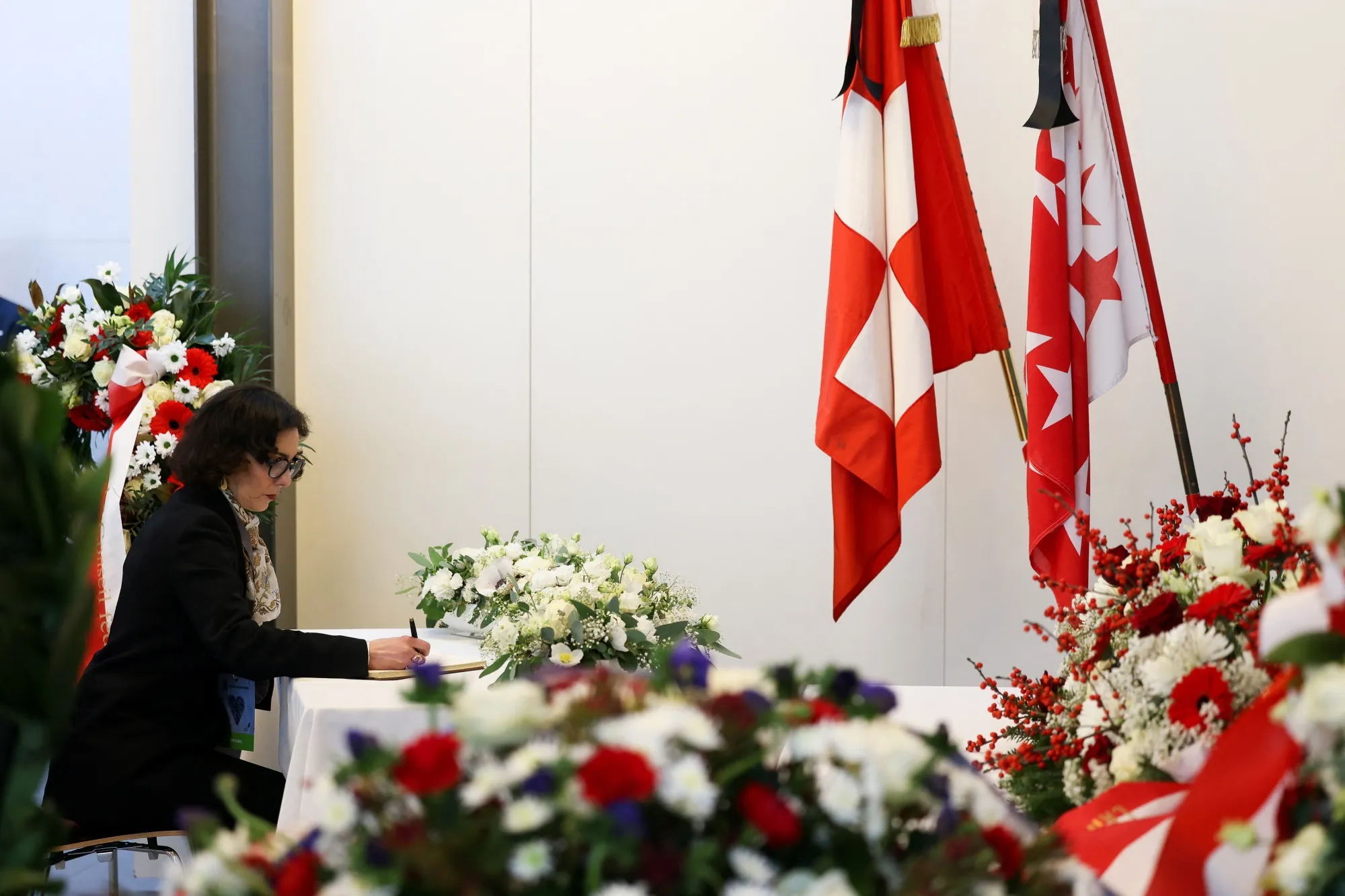 EU Commissioner Hadja Lahbib writes&nbsp;in a memorial book ahead of a tribute ceremony for the victims of the fire, in Martigny, on Jan. 9.&nbsp;