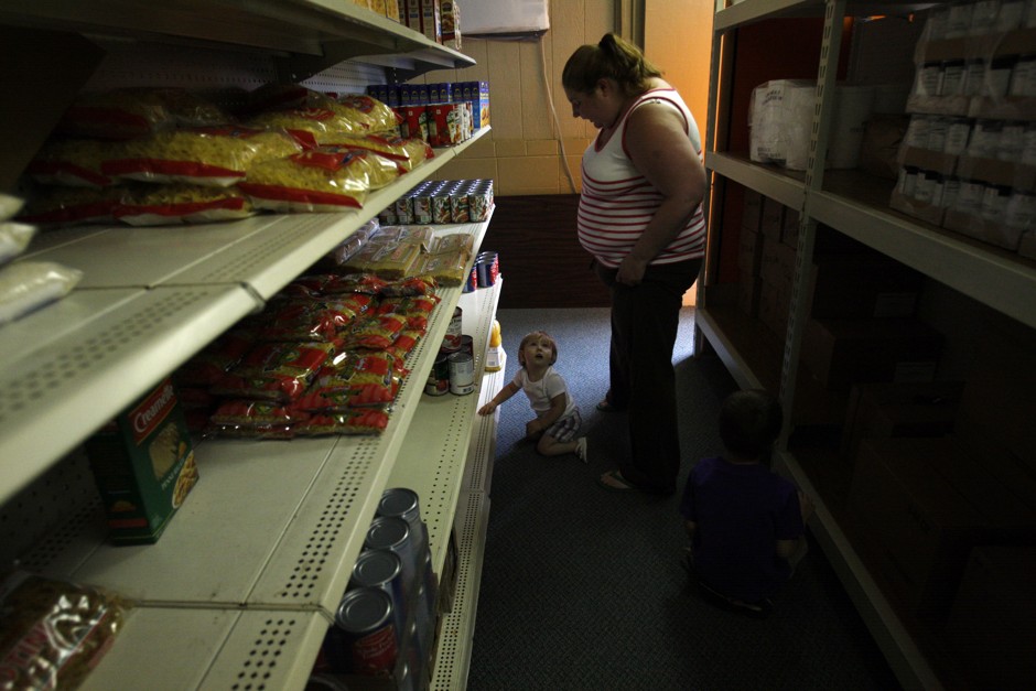 Katie Busker, a resident of Independence, Iowa, pictured in 2011 at a food pantry with her niece. Busker used the food pantry services to make up for the gap in the food assistance she received through SNAP.