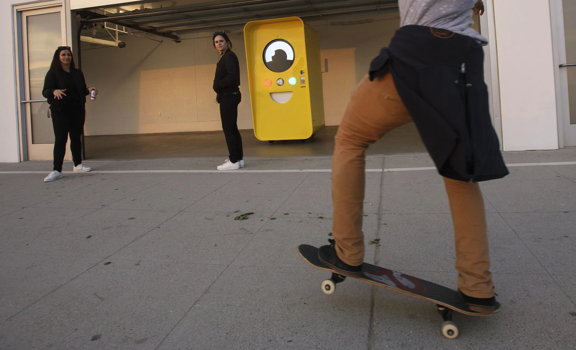 A man skateboards past a Snapchat Spectacles by Snap Inc. vending machine pop-up store in the Venice neighborhood of Los Angeles, on March 14, 2017.
