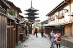 Visitors take photographs on Ninen-zaka slope as the Hokanje temple stands in Kyoto.