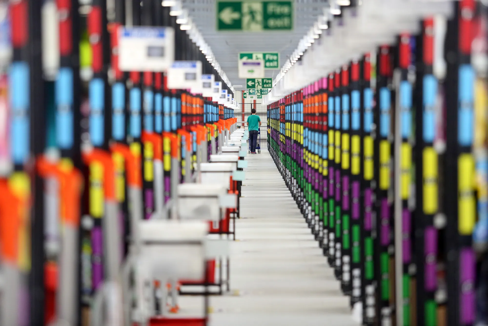 An employee pushes a trolley along an aisle at the Amazon.com Inc. fulfillment center in Hemel Hempstead, U.K.