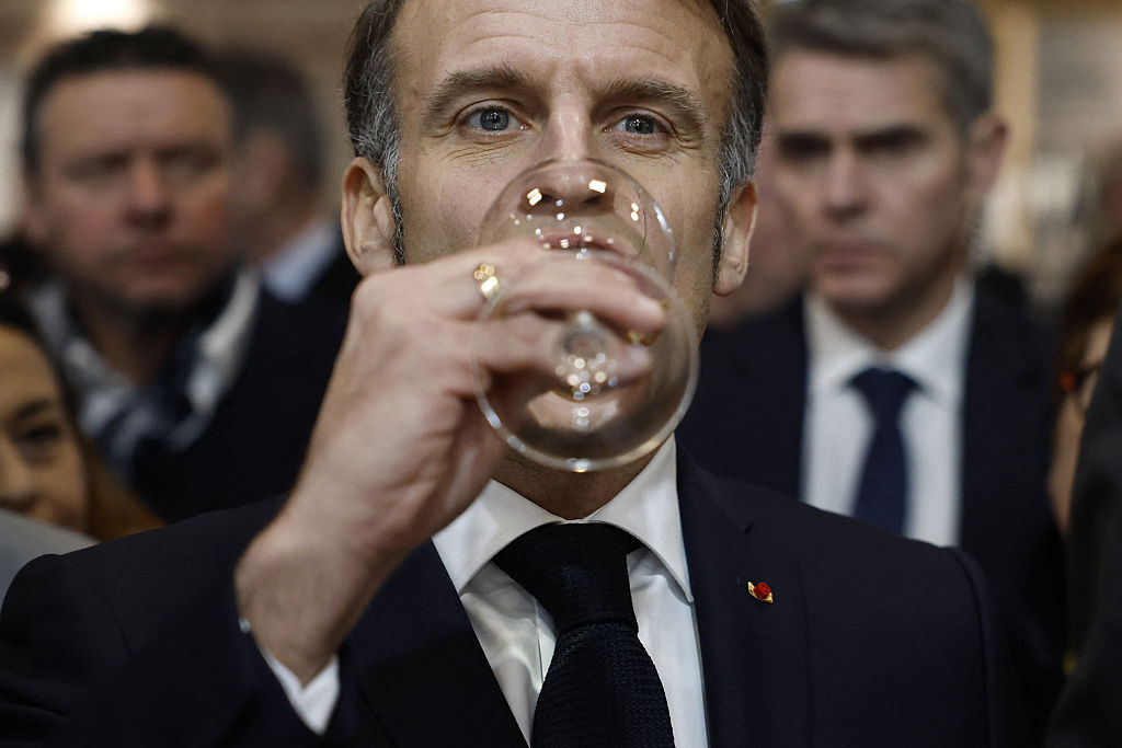 France's President Emmanuel Macron holds a glass of wine as he visits the Wine Paris 2026 fair at the Porte de Versailles exhibition center in Paris on February 9, 2026. (Photo by Yoan VALAT / POOL / AFP via Getty Images) Photographer: YOAN VALAT/AFP