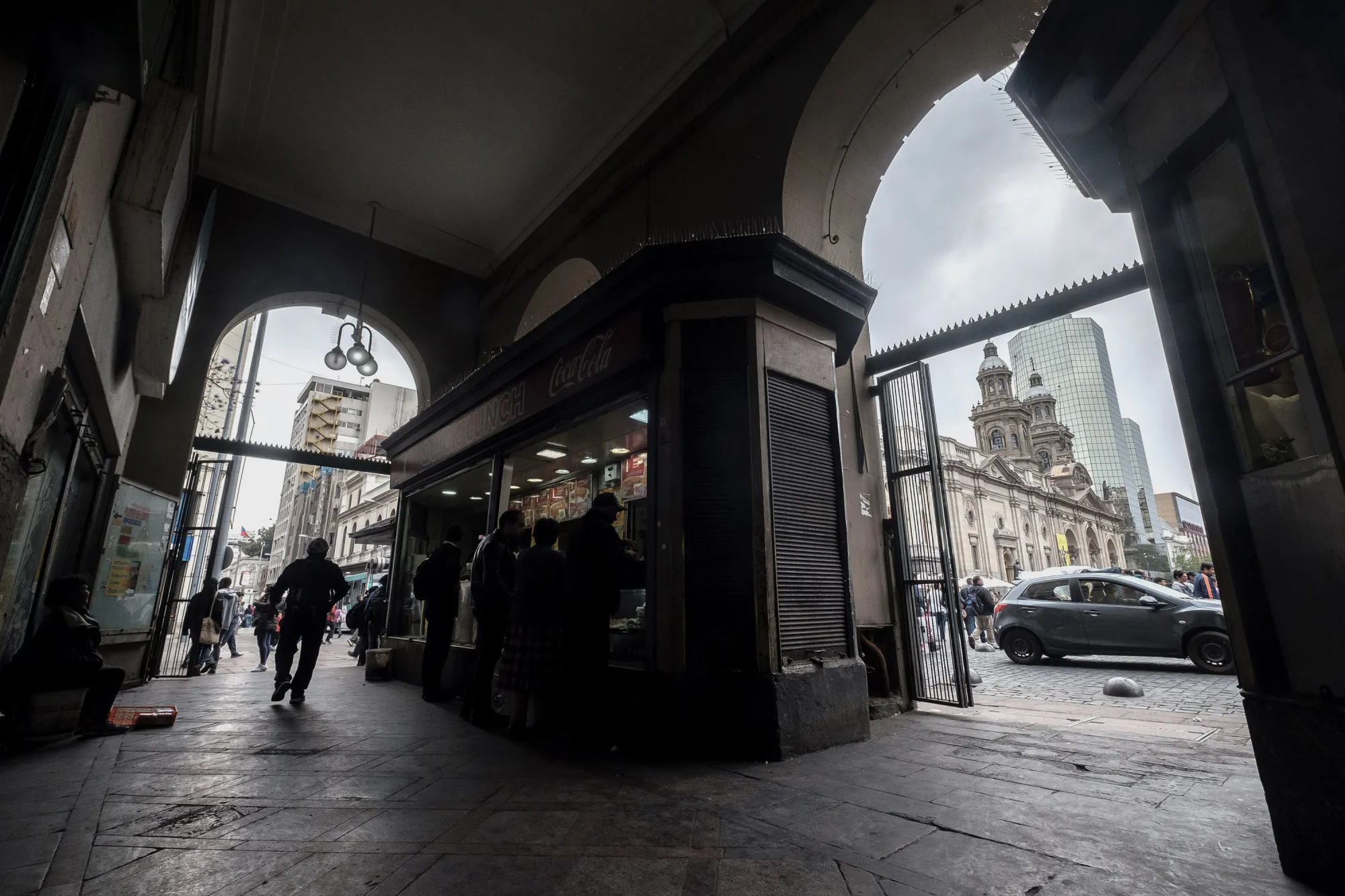 The silhouettes of shoppers are seen purchasing food at a stand in Santiago, Chile.