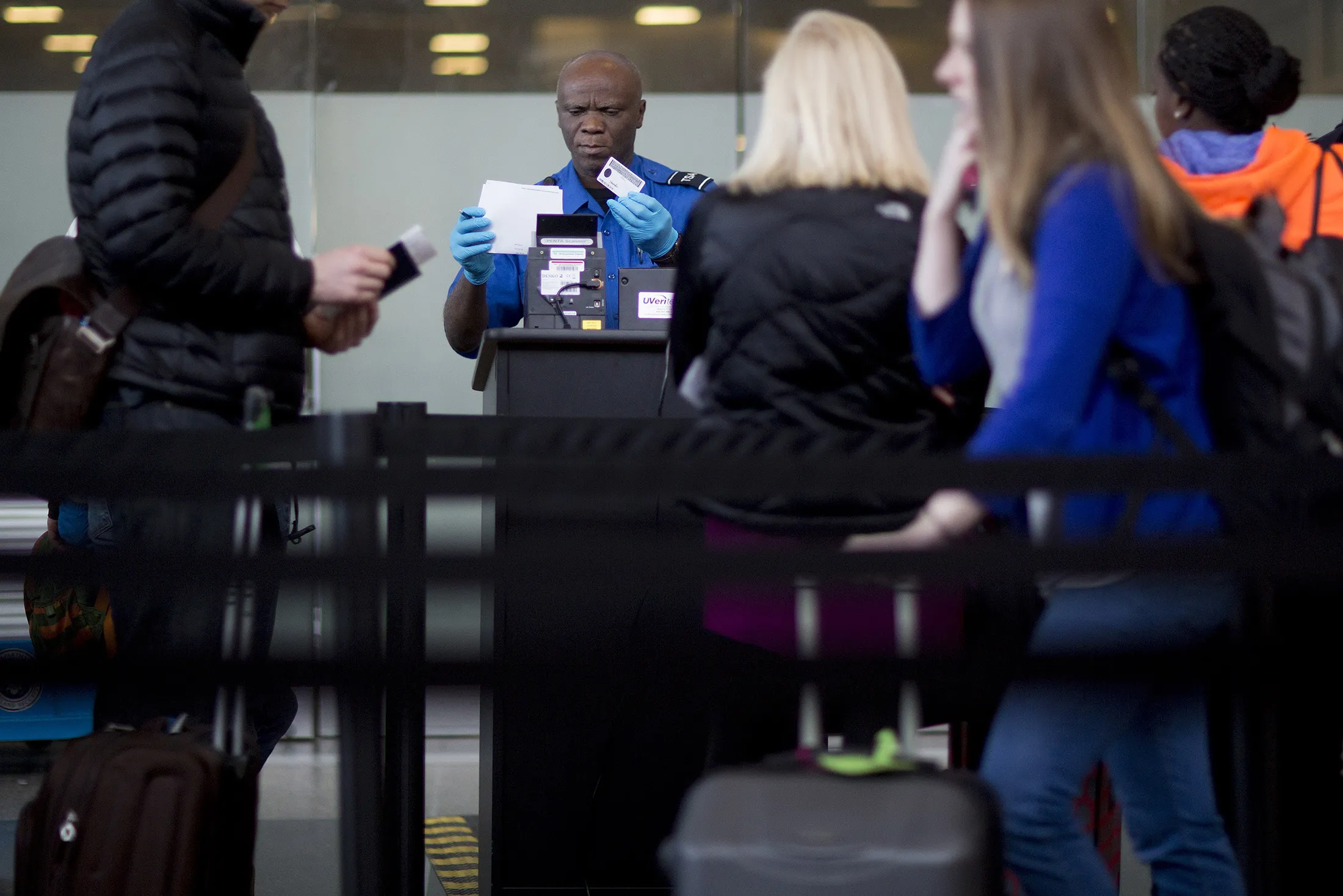 A Transportation Security Administration (TSA) officer checks a passenger's identification and boarding pass at a security checkpoint at Ronald Reagan National Airport (DCA) in Washington, D.C.