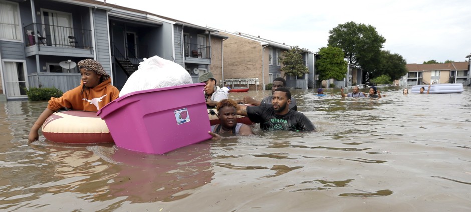 Texas residents flee a flooded apartment building on April 18, 2016.
