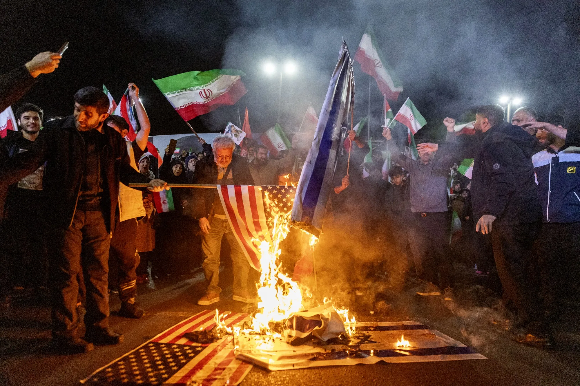 米国とイスラエルの国旗を燃やすイラン市民（テヘランで、3月17日）