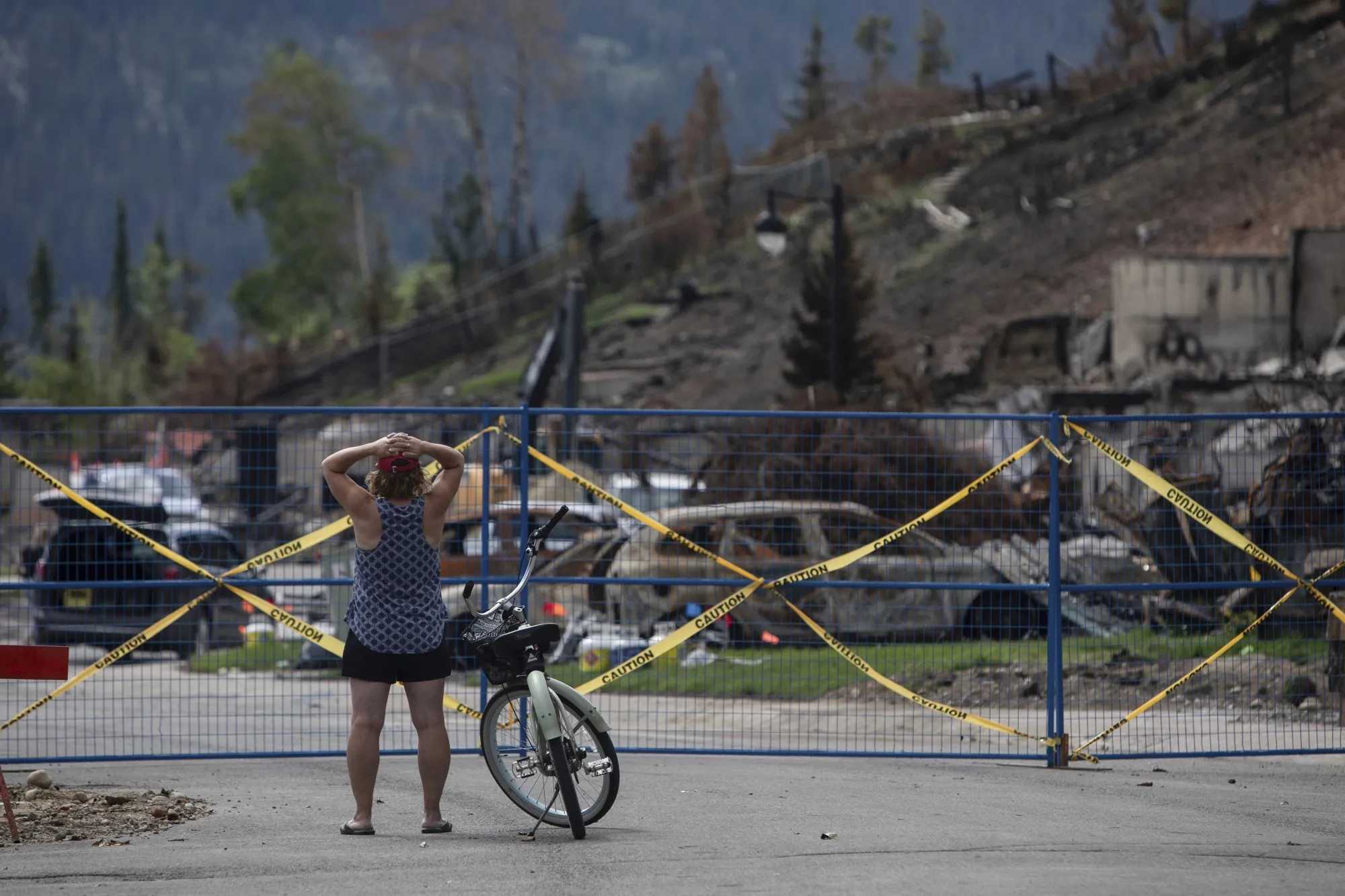 A cyclist looks toward&nbsp;a neighborhood damaged by wildfires&nbsp;in Jasper, Alberta, on Aug. 19.