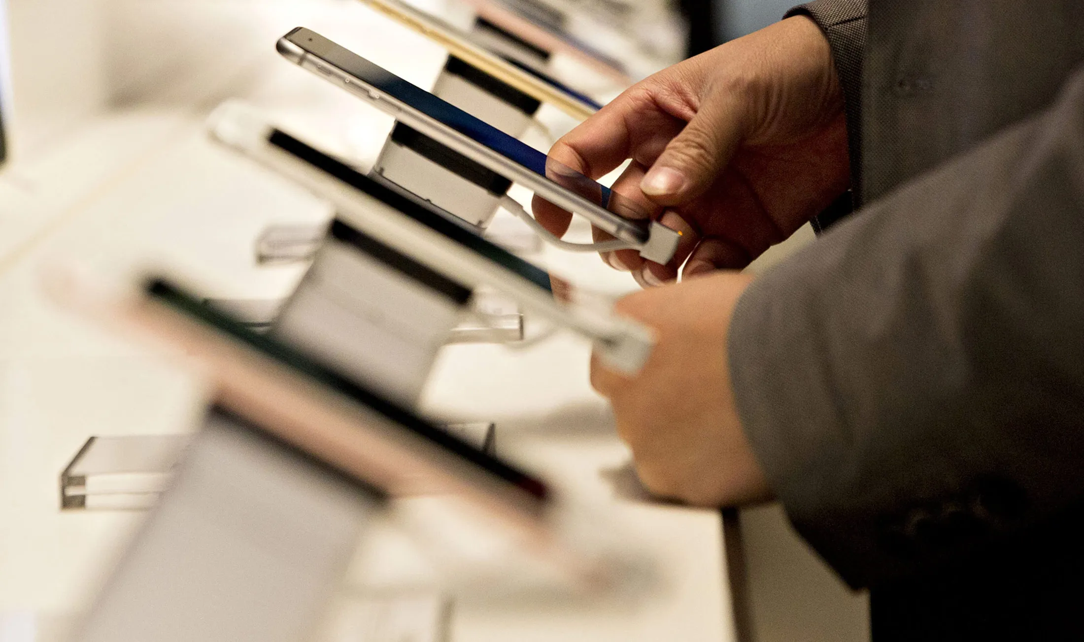 A shopper looks over a display of Apple Inc. iPhones at a T-Mobile US Inc. store in Chicago, Illinois, U.S.