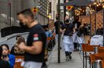 Workers assist diners at a restaurant in New York.
