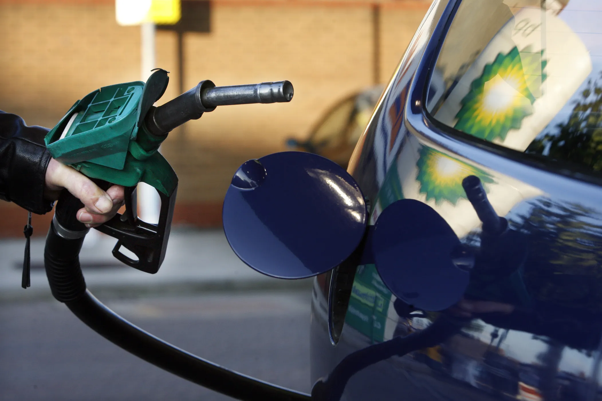 A motorist fills his car at a gas station.