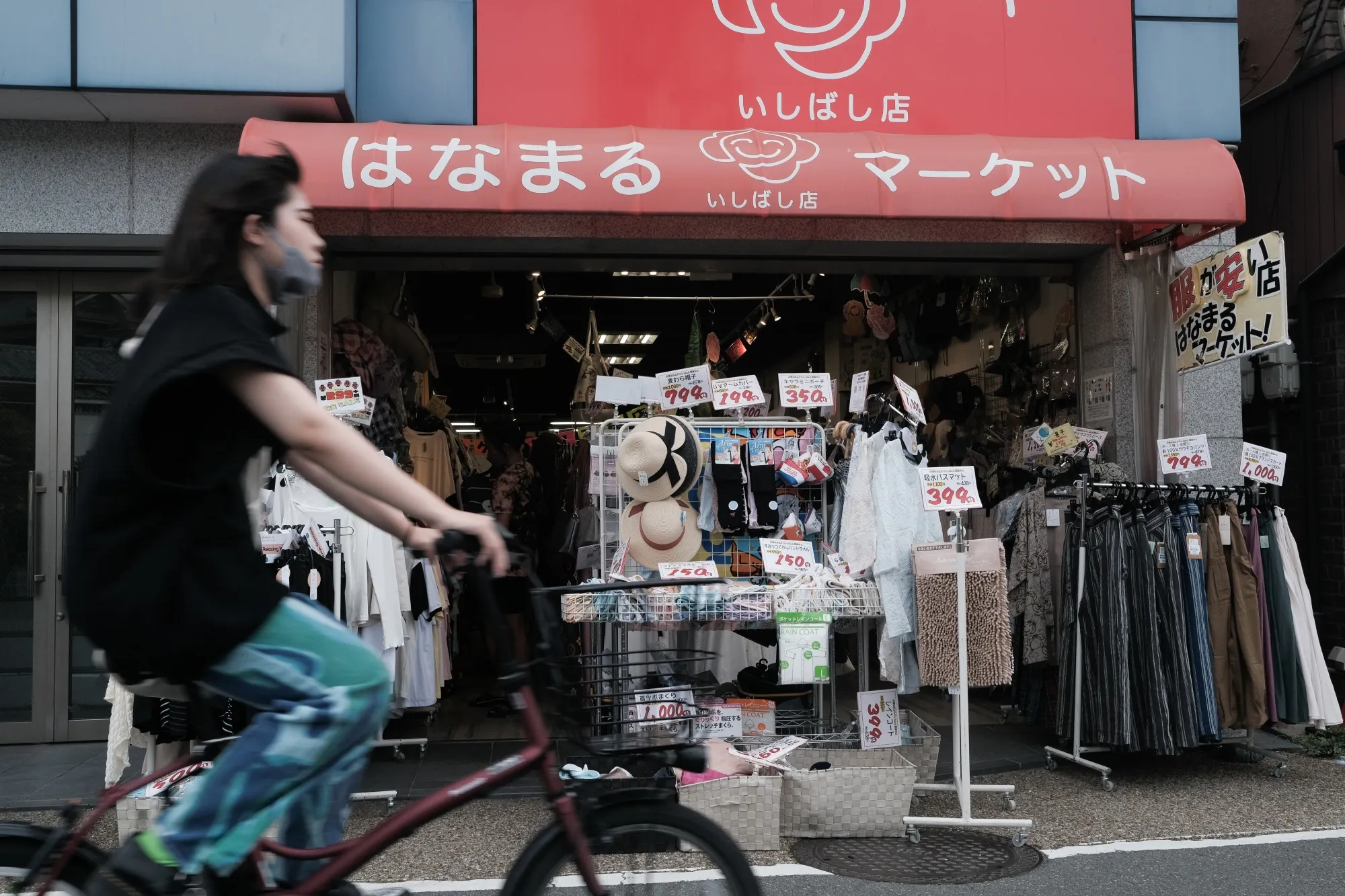 A cyclist pases&nbsp;a clothing shop in Ikeda, Osaka Prefecture, Japan.