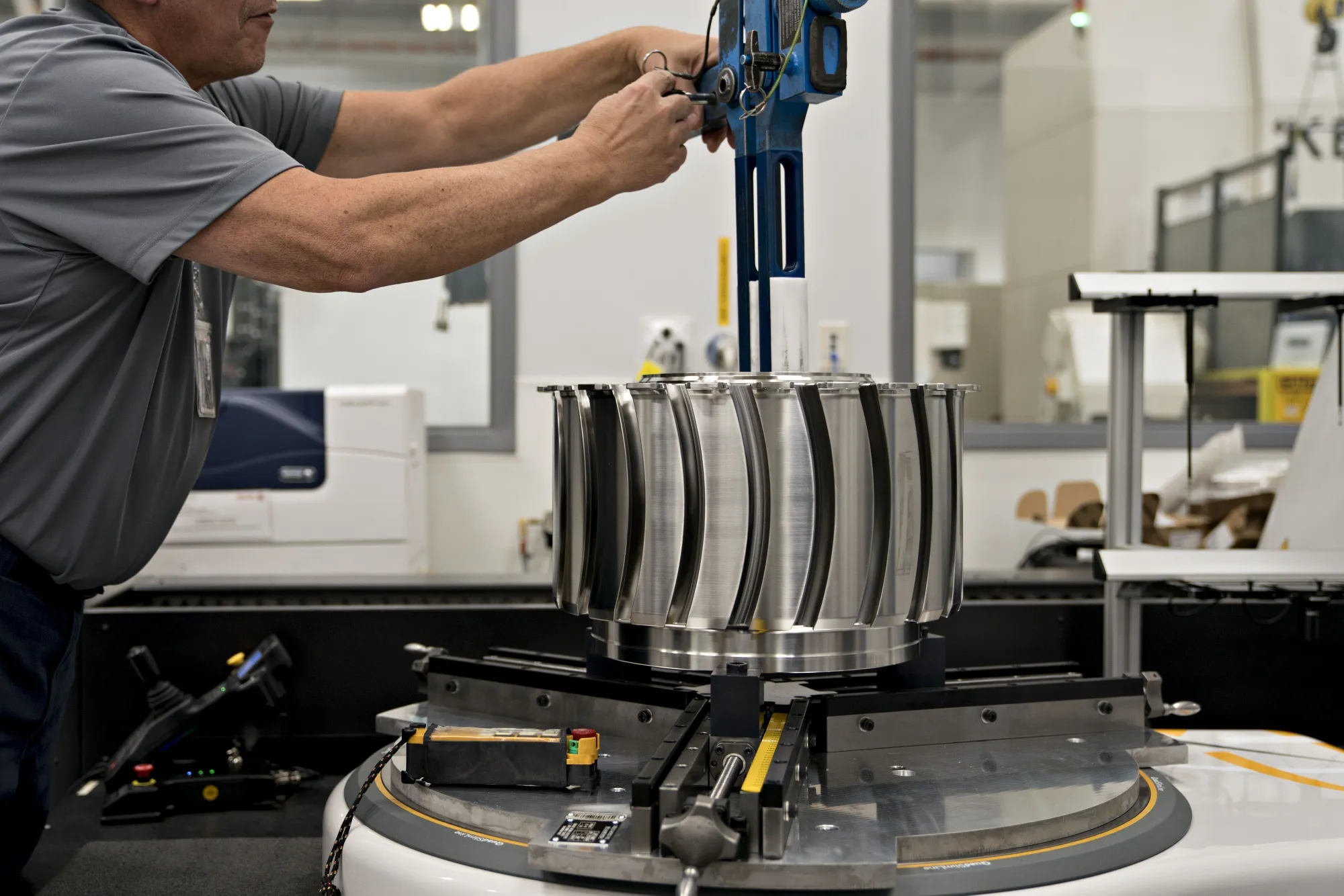An employee adjusts a titanium alloy aircraft engine fan disc&nbsp;at a Rolls-Royce North America Inc.&nbsp;facility in Prince George, Virginia.