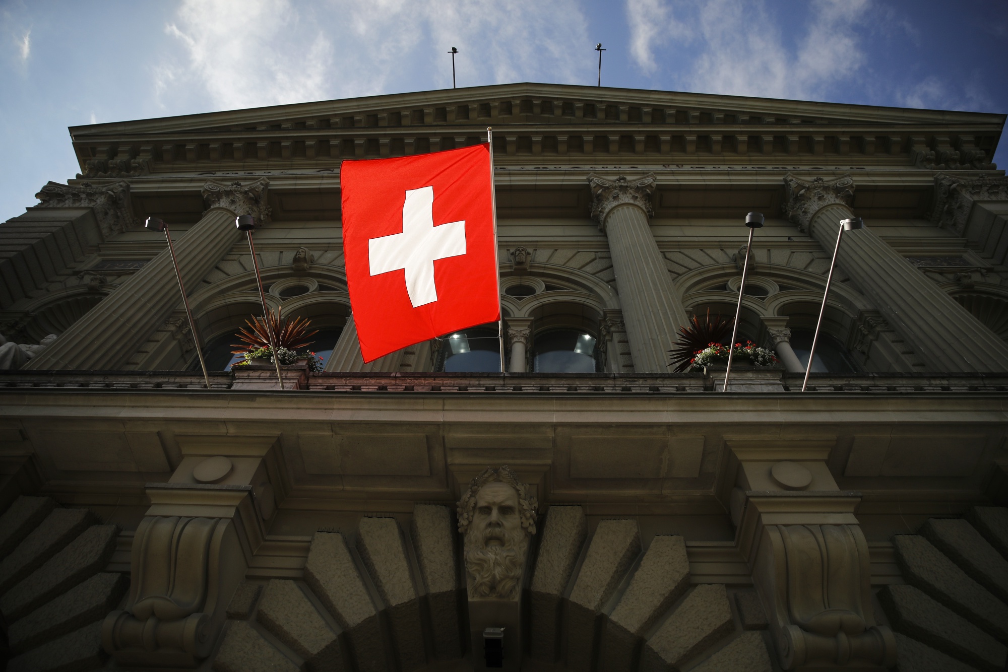 The Swiss national flag hangs from the Federal Palace, Switzerland's parliament building, in Bern.