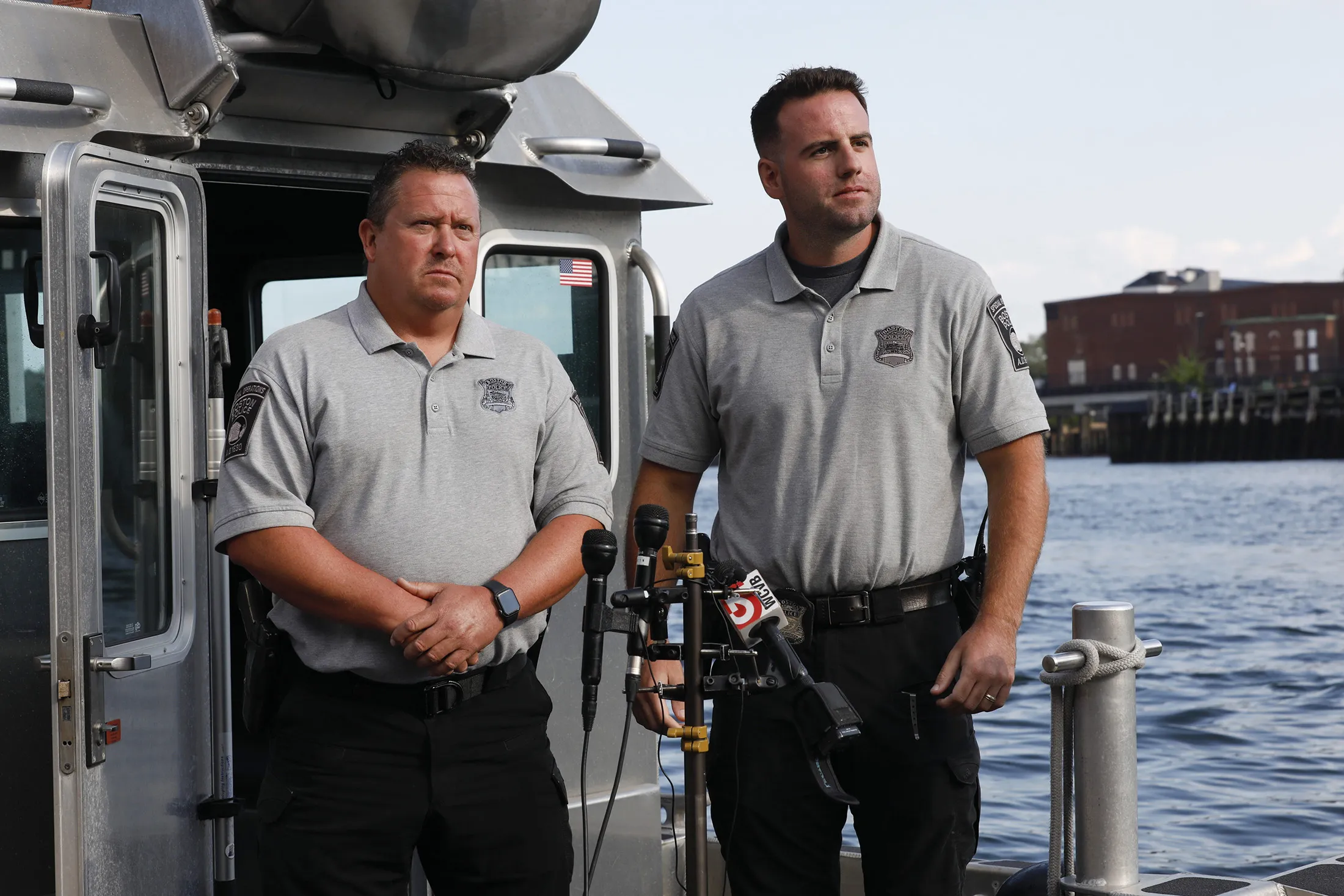 Officers Stephen Merrick, left, and Garrett Boyle, right, speak at a press conference at the Boston Harbor Patrol dock after rescuing&nbsp;two people aboard a sinking boat.