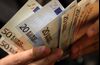 A man counts euro notes in this arranged photograph.